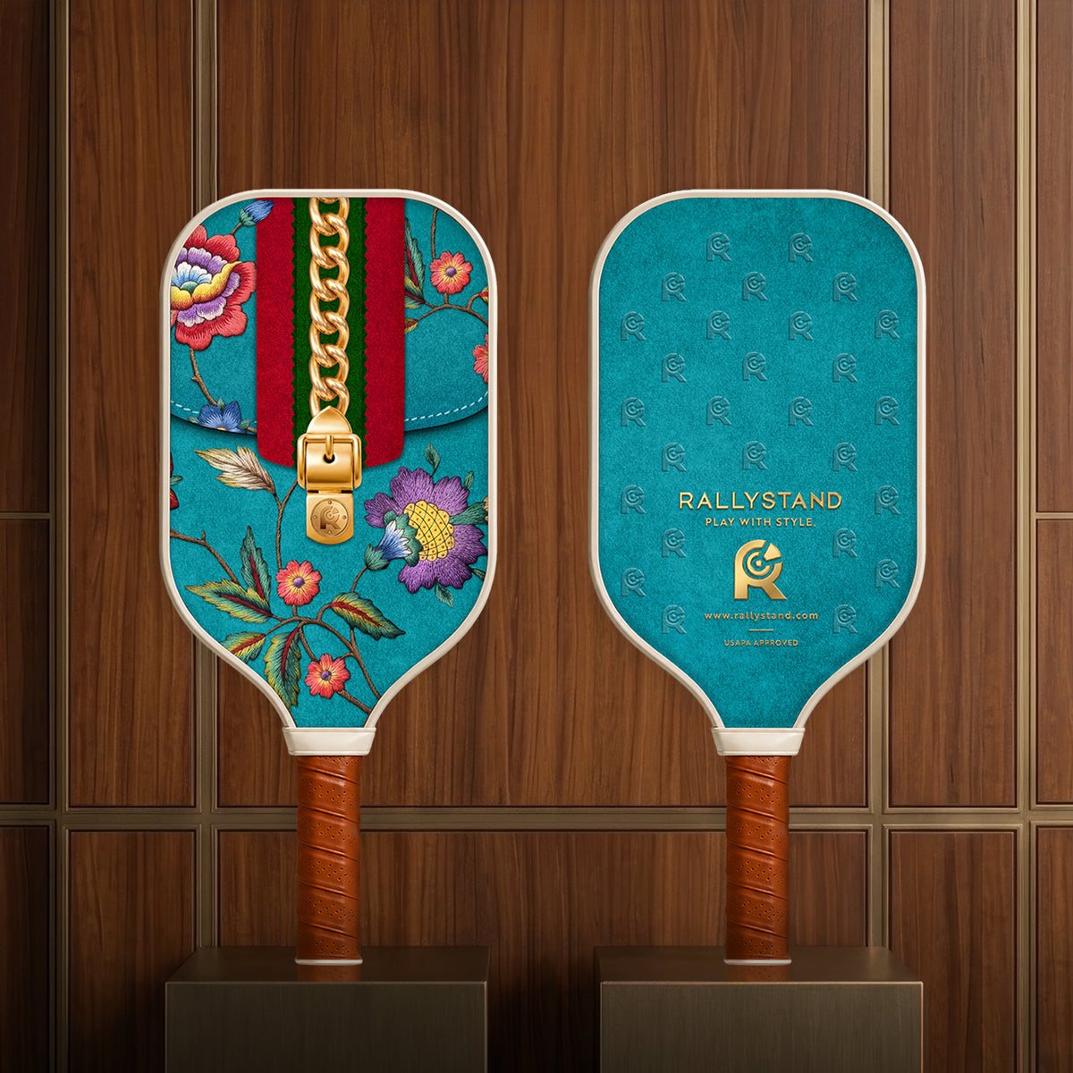 Front and back view of the RallyStand premium floral and monogram print pickleball paddles showcased on luxury dark wood retail display stands.