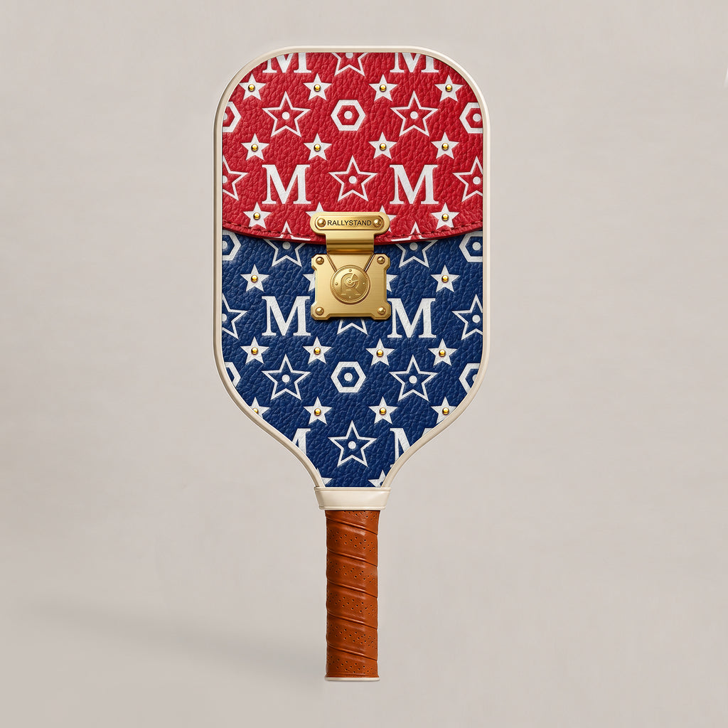 Front view of a luxury RallyStand pickleball paddle featuring a college red, white, and blue designer handbag aesthetic with gold hardware accents.