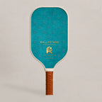 Back view face of RallyStand luxury designer performance pickleball paddle with teal monogram background pattern and a gold brand logo emblem.