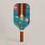 Front view face of RallyStand luxury designer pickleball paddle featuring a teal monogram pattern, red and green stripes, golden zipper graphic, and vibrant floral embroidery details.